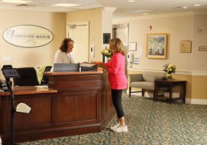 image of family member greeted at Sunnyside Manor reception desk